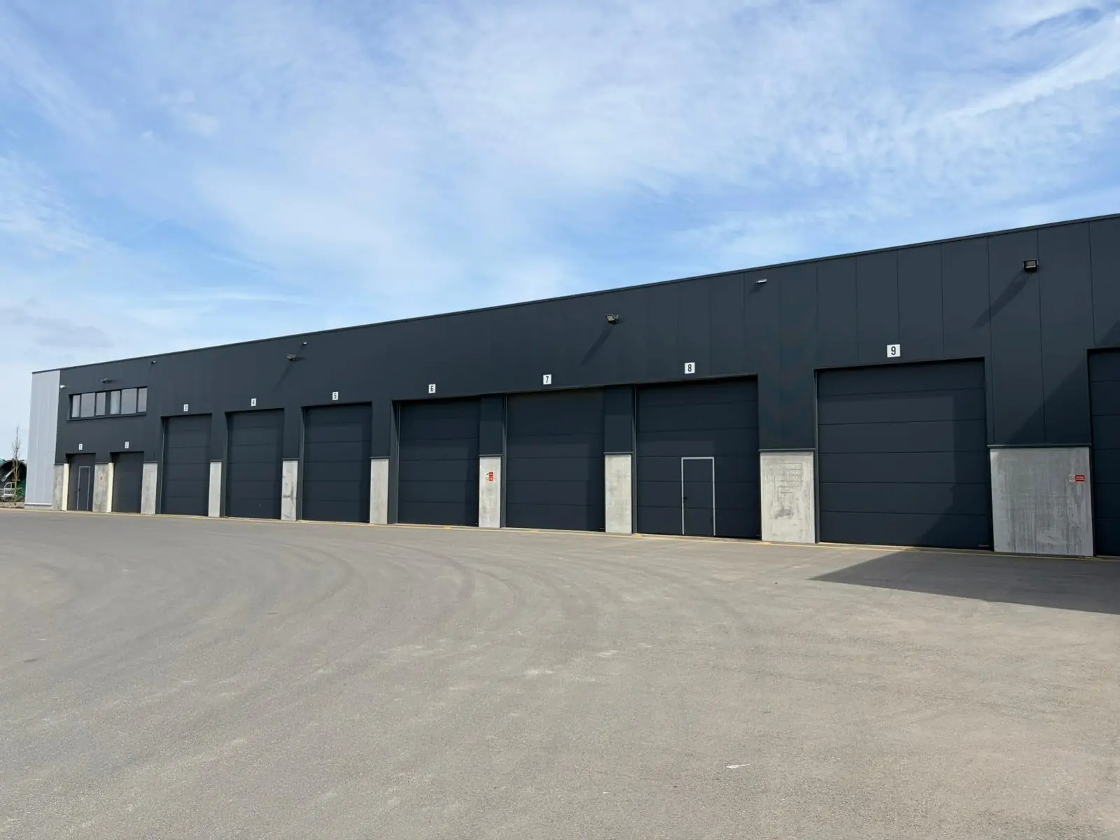 Quai de chargement et portes sectionnelles du hall industriel Witrans, zoning de Bastogne